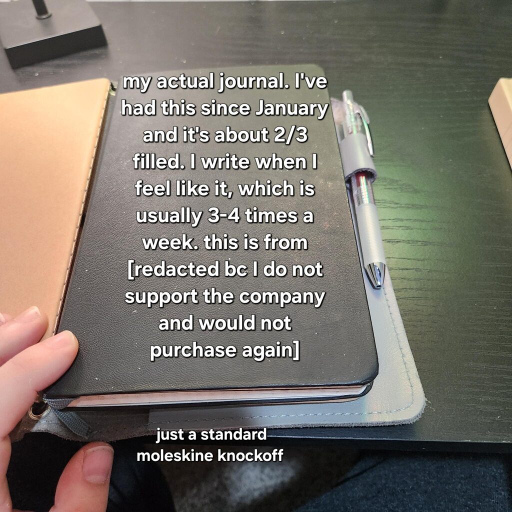 Black A5 journal, looks similar to a moleskine. Text: "my actual journal. I've had this since January and it's about 2/3 filled. I write when I feel like it, which is usually 3-4 times a week. this is from [redacted bc I do not support the company and would not purchase again]"